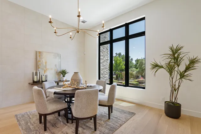 a living room with furniture a chandelier a rug and a window