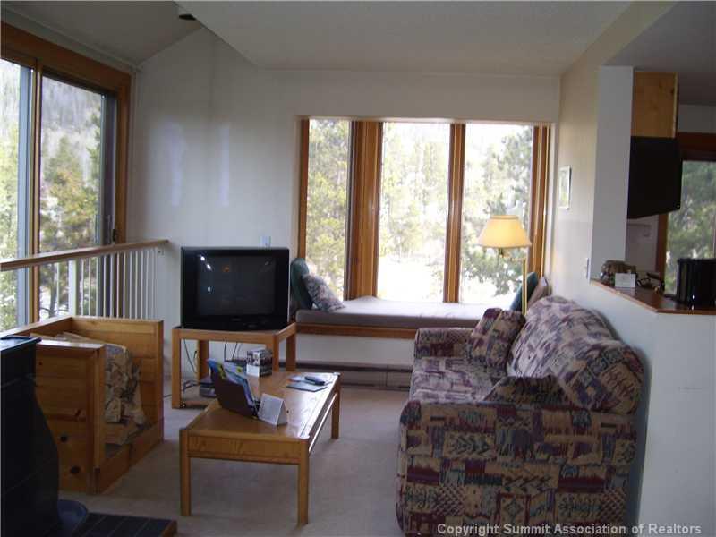 22340 Highway 6, Unit 1815 Keystone, CO 80435 - Photo 4 of 12 a living room with furniture a flat screen tv and a large window