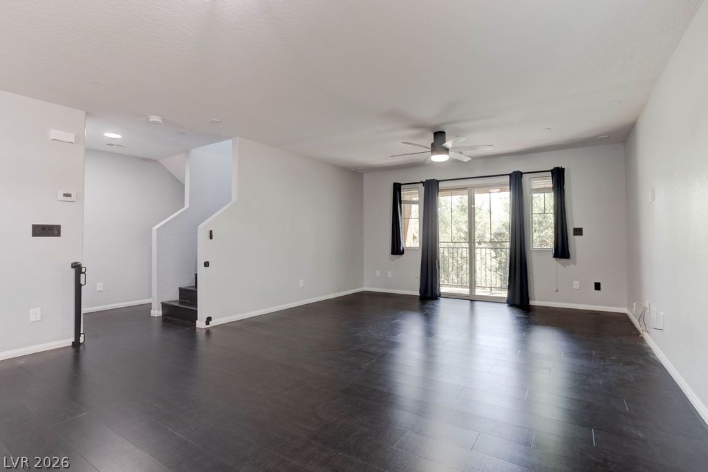 7724 Vibrant Thread Court Las Vegas, NV 89149 - Photo 16 of 43 Rich dark wood flooring anchors this open living space, leading to sliding glass doors that invite abundant natural light.