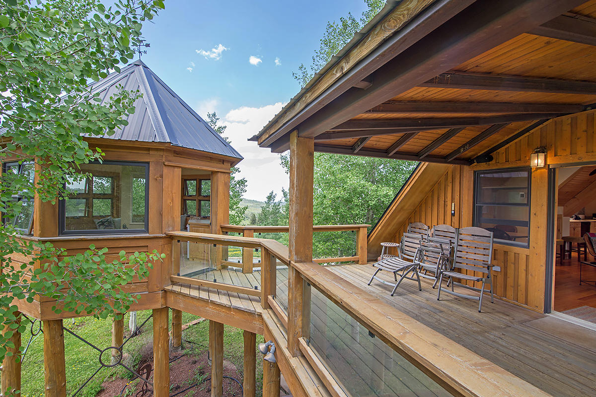 3520 County 58P Road Placerville, CO 81430 - Photo 36 of 76 a view of a patio with table and chairs under an umbrella with a barbeque