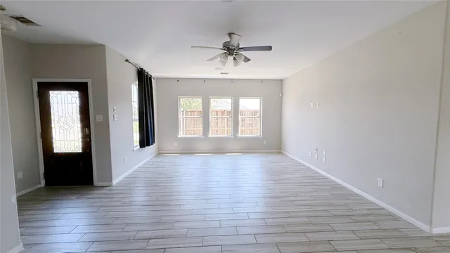 wooden floor in an empty room with a window