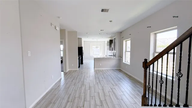 a view of a hallway with wooden floor and staircase