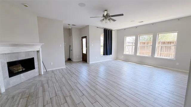 a view of an empty room with a window and fireplace