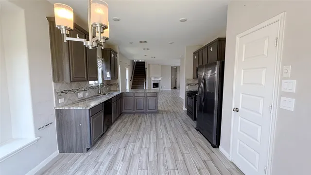a large kitchen with a wooden floor and a refrigerator
