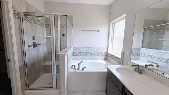 a bathroom with a tub sink vanity granite and mirror