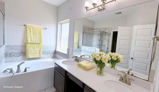 a bathroom with a tub sink and mirror