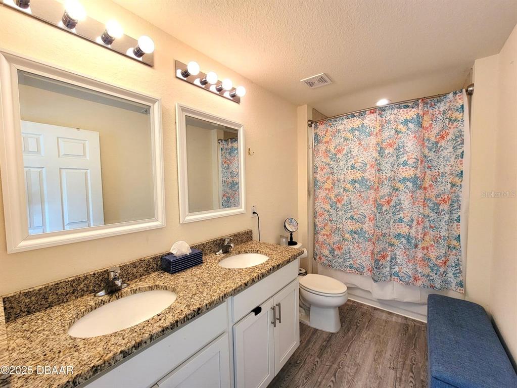 5023 Littlefield Road LaBelle, FL 33935 - Photo 18 of 36 a bathroom with a granite countertop sink toilet a mirror a shower and a double vanity