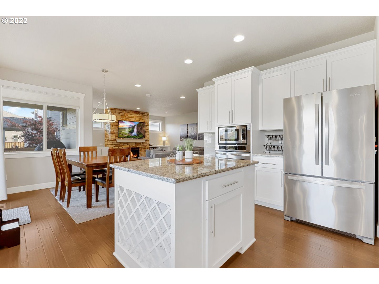 1845 South 14th Court Ridgefield, WA 98642 - Photo 8 of 32 a kitchen with stainless steel appliances kitchen island granite countertop a refrigerator a stove a sink a dining table and chairs