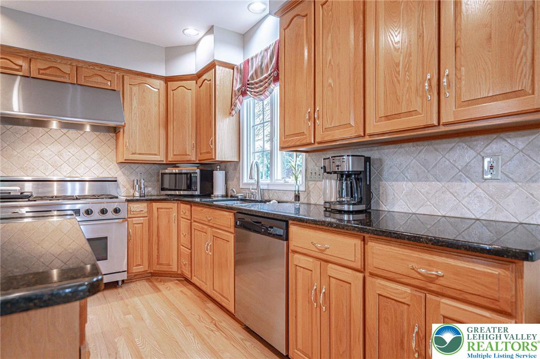 6551 Overlook Road Orefield, PA 18069 - Photo 24 of 82 a kitchen with stainless steel appliances granite countertop a sink a stove and cabinets