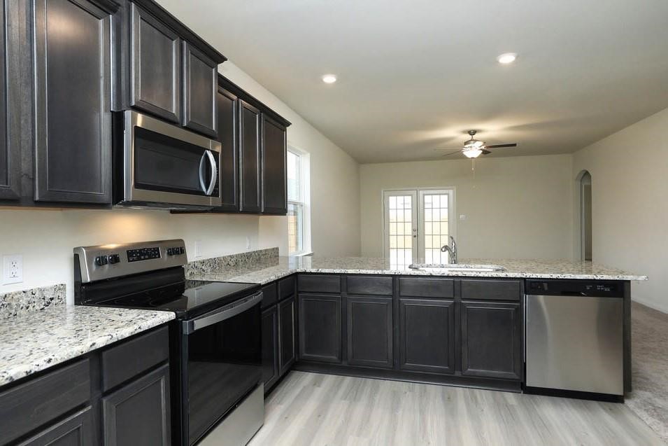 22422 Kennons Way Hockley, TX 77447 - Photo 4 of 11 a kitchen with a sink and stove top oven