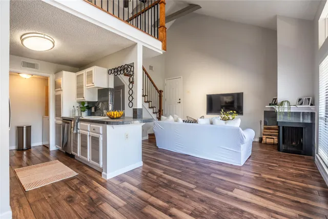 a large white kitchen with kitchen island a large counter space a sink a window and stainless steel appliances