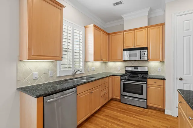 a kitchen with stainless steel appliances granite countertop a stove and a sink