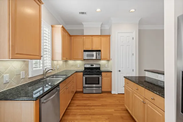 a kitchen with stainless steel appliances a refrigerator and a stove top oven