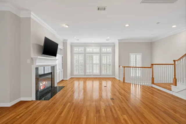 a view of empty room with wooden floor and fireplace