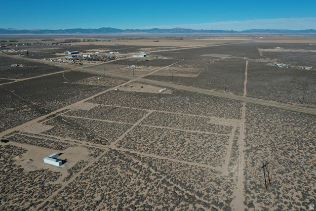 265 South 700 East Beryl, UT 84714 - Photo 2 of 10 Aerial view of property and surrounding area featuring a mountainous background and rural landscape