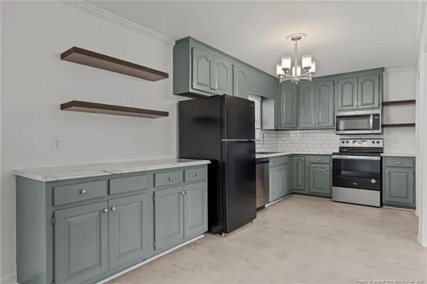 a kitchen with kitchen island a sink stainless steel appliances and a chandelier