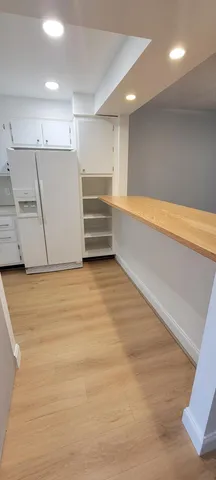 a kitchen with granite countertop white cabinets and white stainless steel appliances