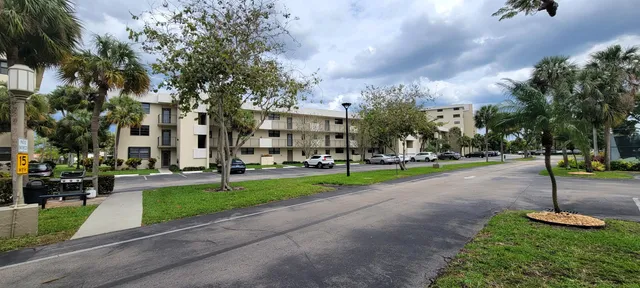 a view of a house with a yard and a large tree