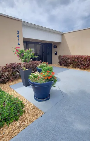 a view of patio with a table and chairs under an umbrella with a small yard
