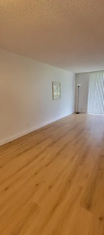 a view of an empty room and wooden floor