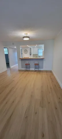 a view of an empty room with kitchen counter space and a sink