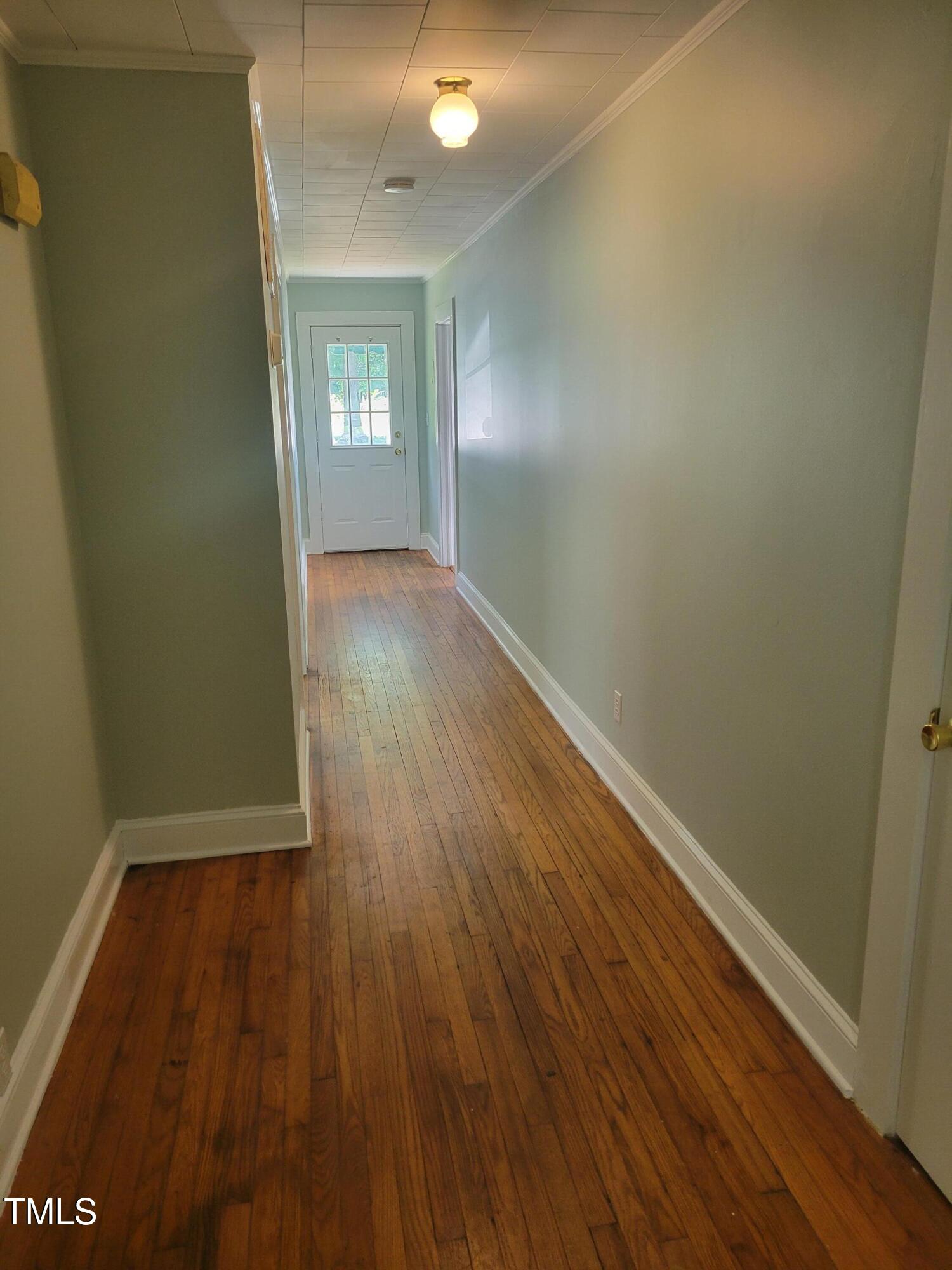 411 West Raleigh Street Siler City, NC 27344 - Photo 11 of 33 an empty room with wooden floor and windows