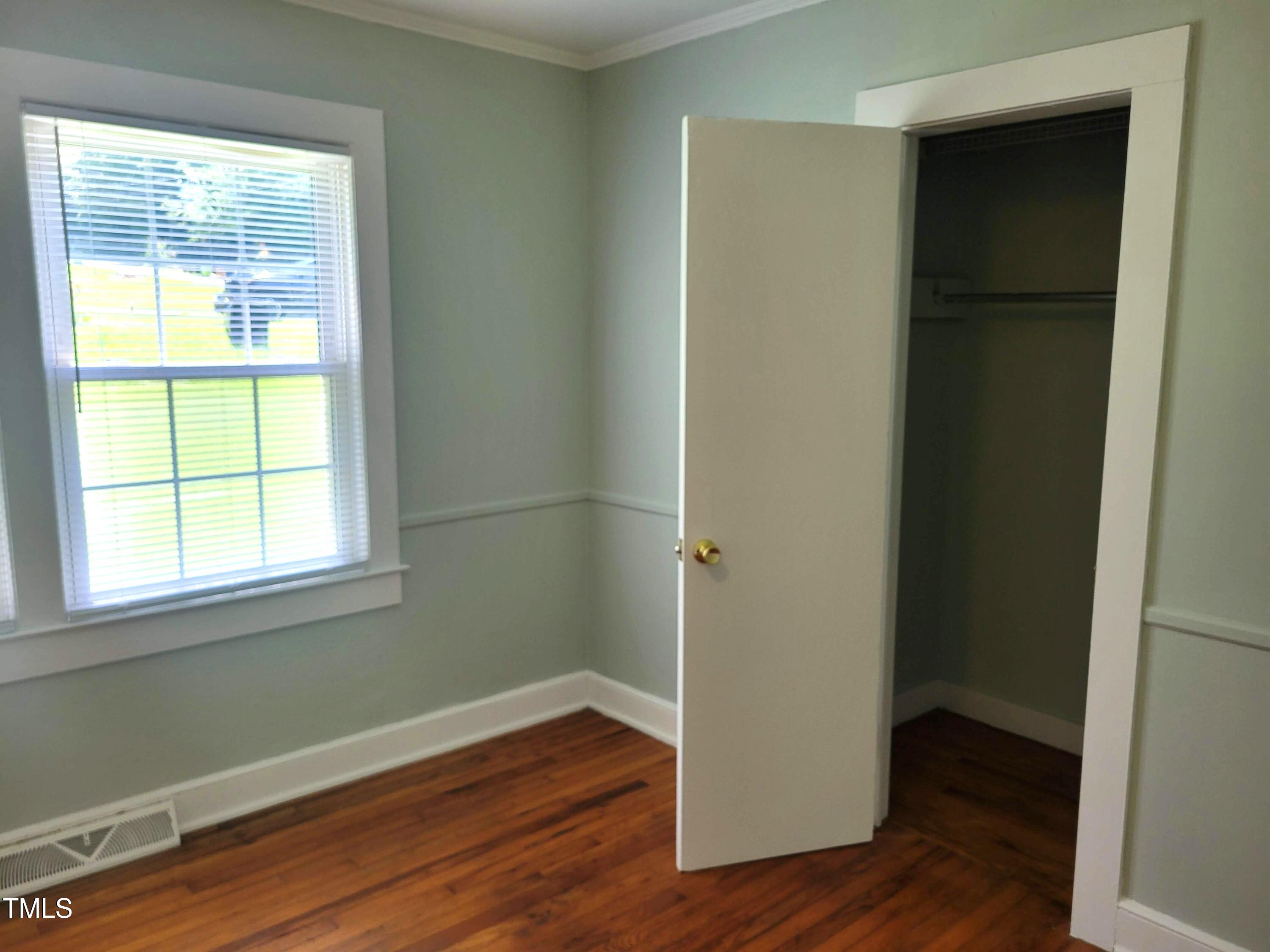411 West Raleigh Street Siler City, NC 27344 - Photo 15 of 33 a view of an empty room with wooden floor and a window