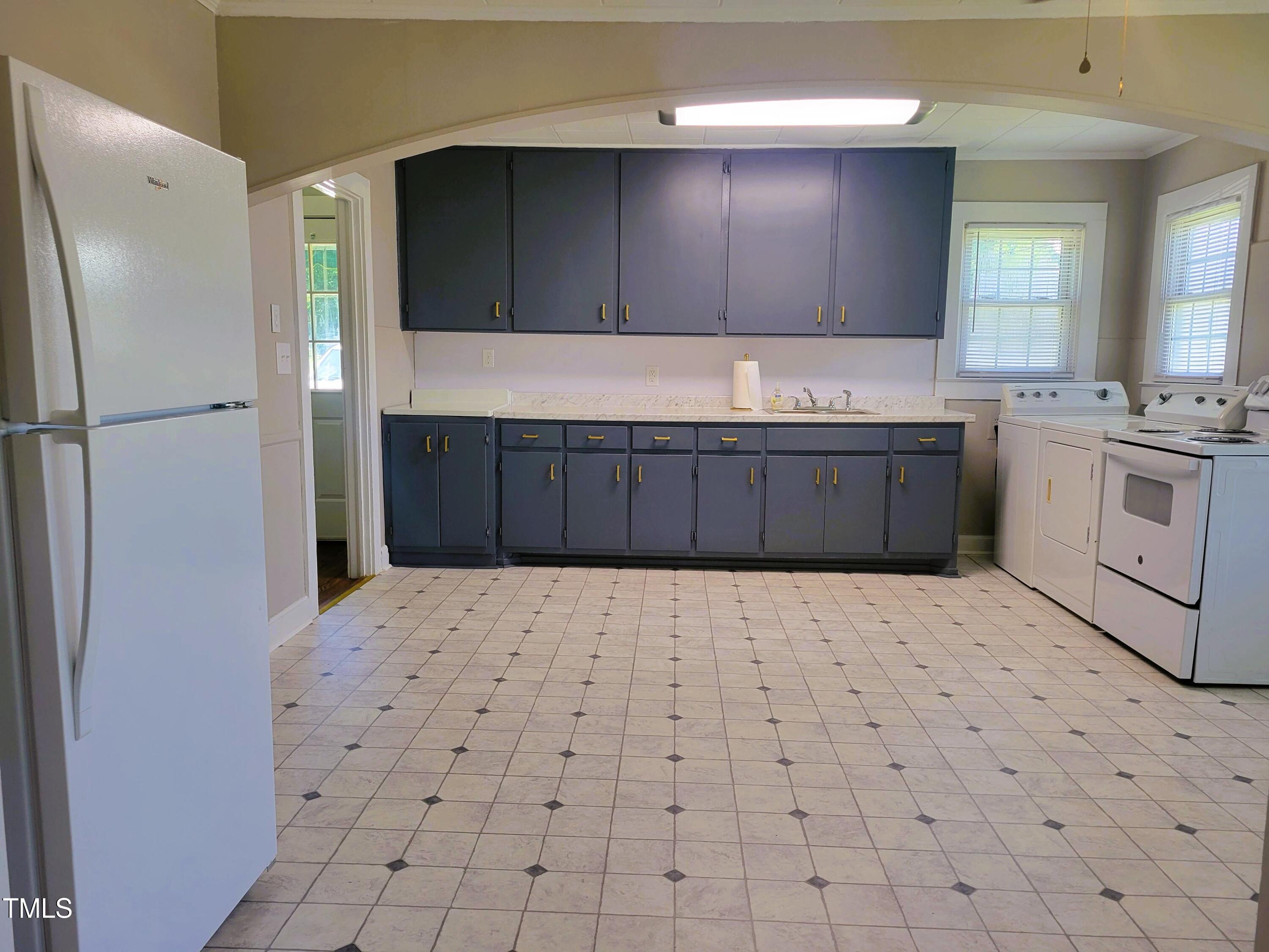 411 West Raleigh Street Siler City, NC 27344 - Photo 6 of 33 a kitchen with stainless steel appliances a refrigerator and a stove
