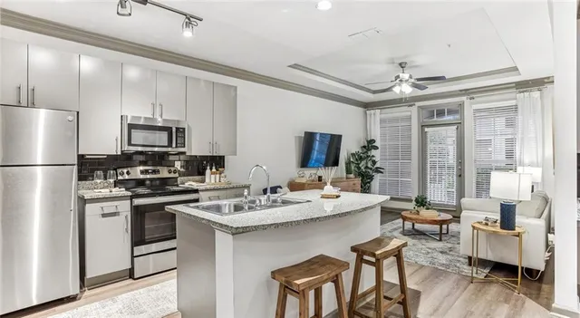 a kitchen with a chandelier stainless steel appliances and dining table
