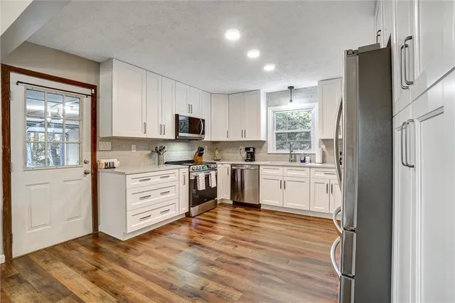 a kitchen with white cabinets and stainless steel appliances