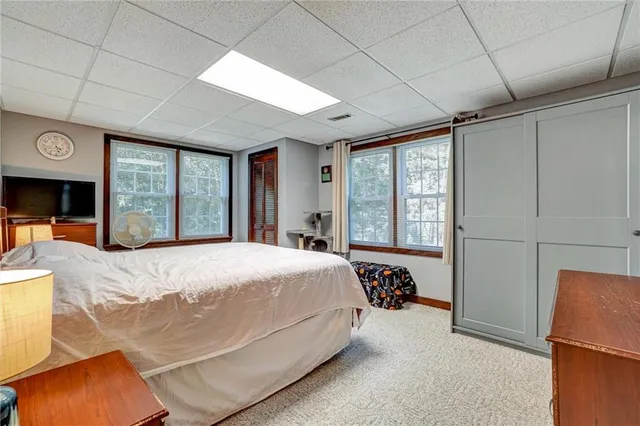 a bedroom with a bed and a large window