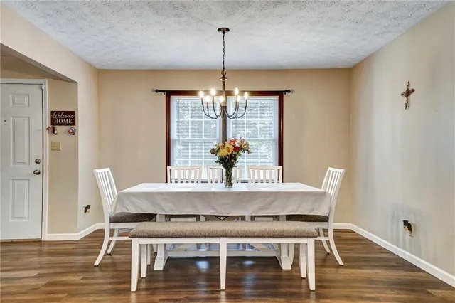 a view of a dining room with furniture wooden floor and chandelier