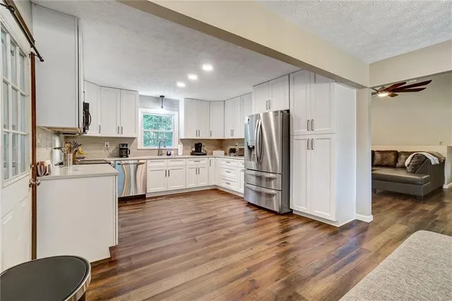 a kitchen with a refrigerator a sink and cabinets