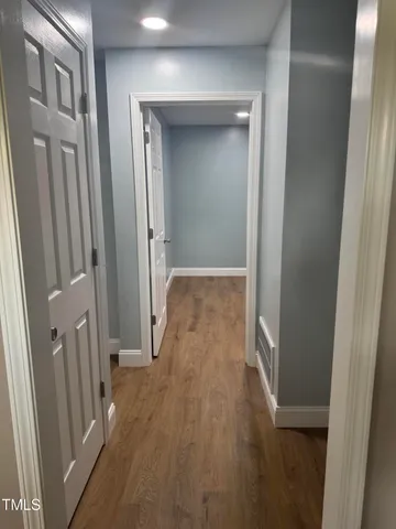 a view of a hallway with wooden floor