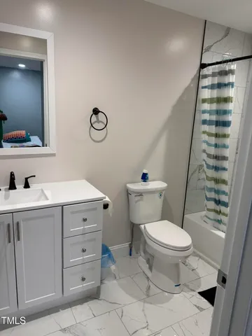a bathroom with a sink a toilet a mirror and shower