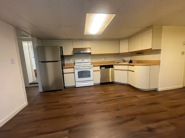 a kitchen with a refrigerator and a stove top oven