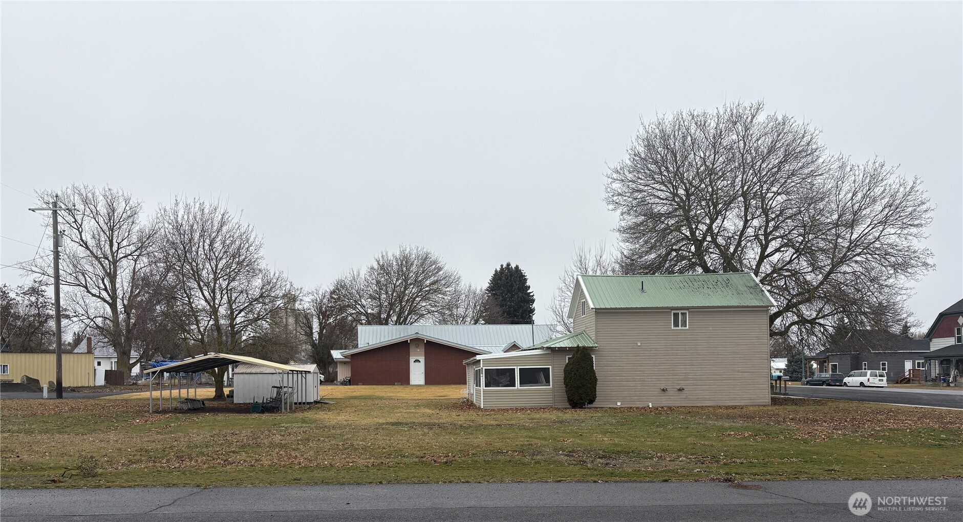 208 North 3rd Street Harrington, WA 99134 - Photo 12 of 16 a view of a white house with a yard and parking space