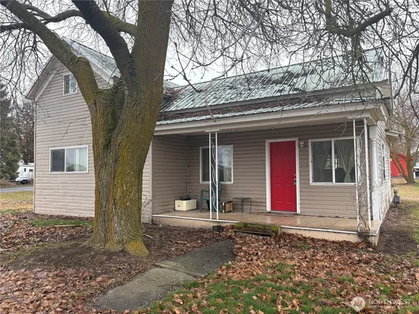 a small house with a tree in front of it