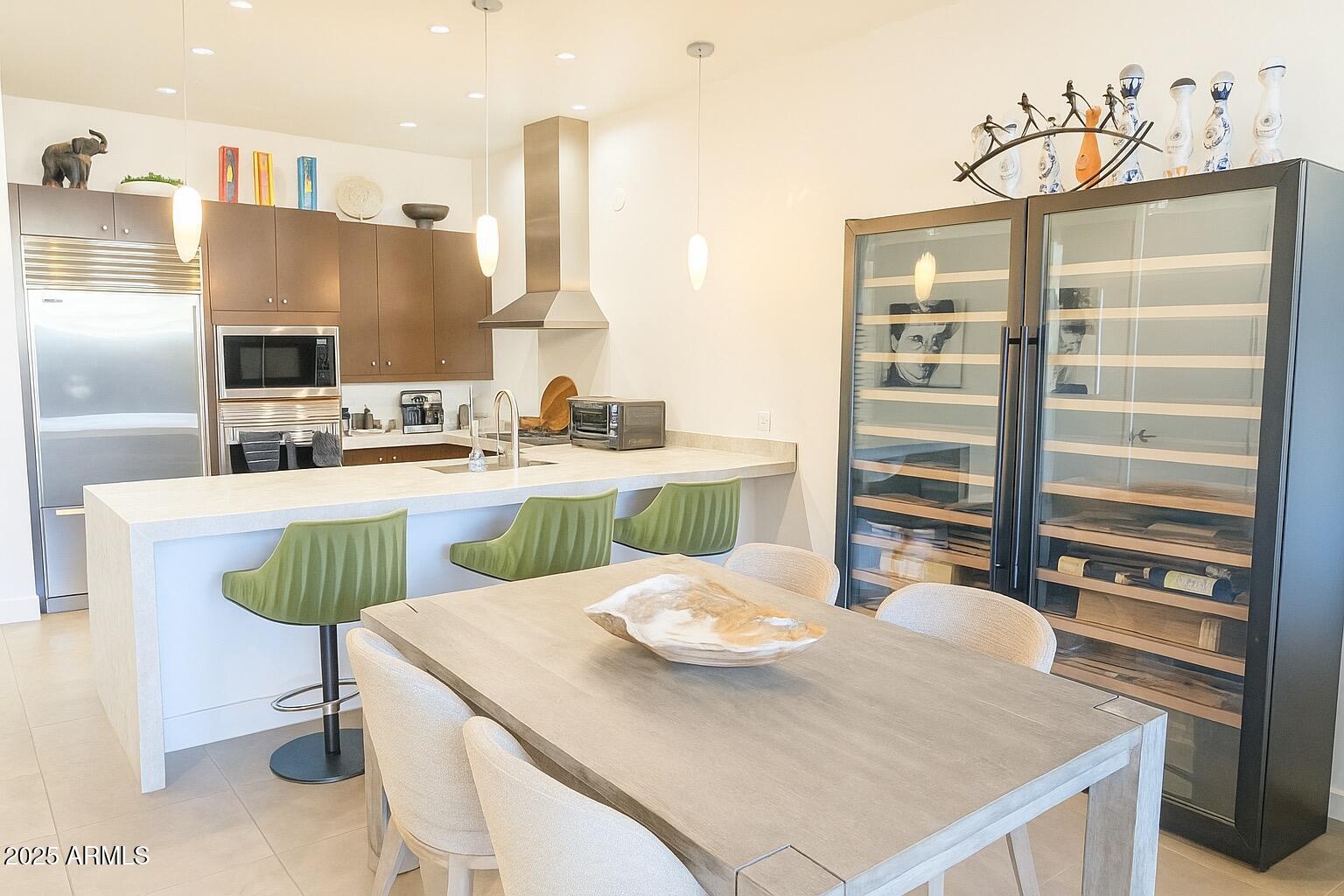 15215 North Kierland Boulevard, Unit 103 Scottsdale, AZ 85254 - Photo 2 of 20 a kitchen with a table chairs and a refrigerator