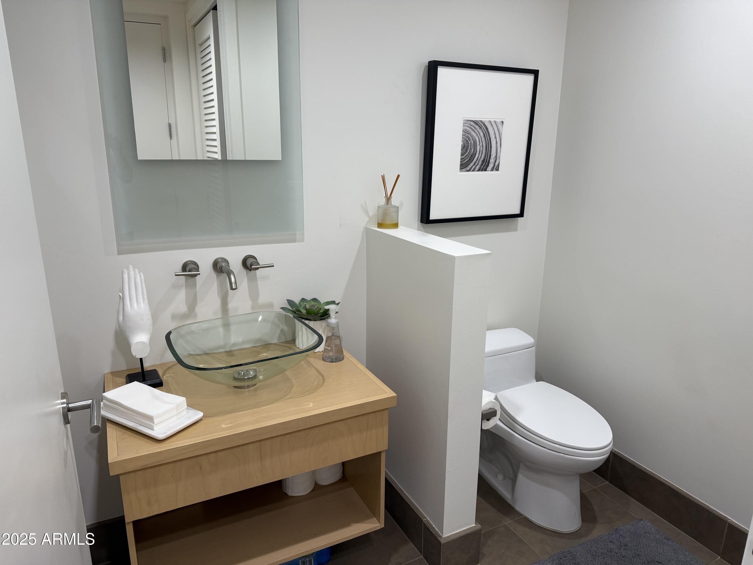 15215 North Kierland Boulevard, Unit 103 Scottsdale, AZ 85254 - Photo 8 of 20 a bathroom with a toilet a sink and mirror