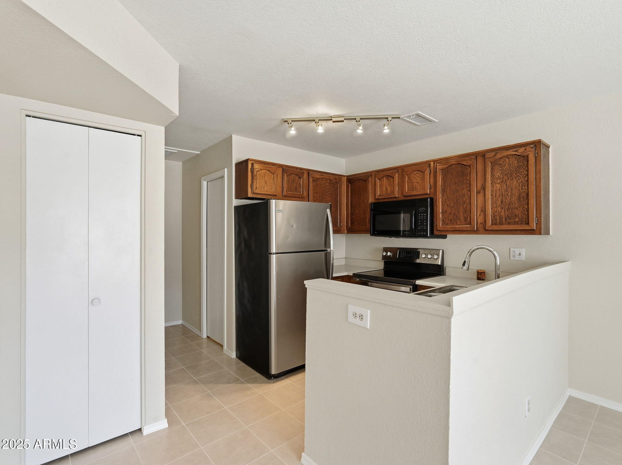 510 North Alma School Road, Unit 223 Mesa, AZ 85201 - Photo 9 of 25 a kitchen with stainless steel appliances a refrigerator sink and microwave