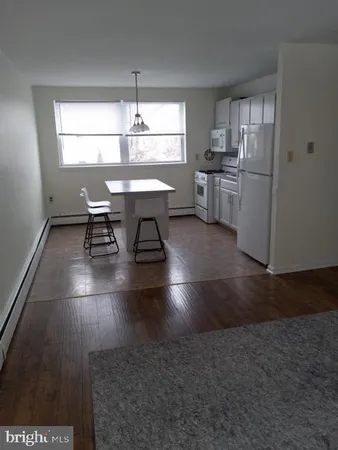 a kitchen with stainless steel appliances a dining table chairs and a refrigerator