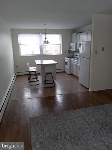 a kitchen with stainless steel appliances a dining table chairs and a refrigerator