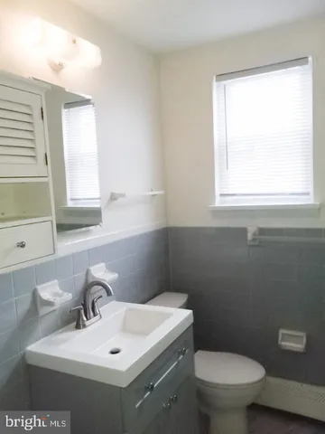 a bathroom with a toilet sink and mirror