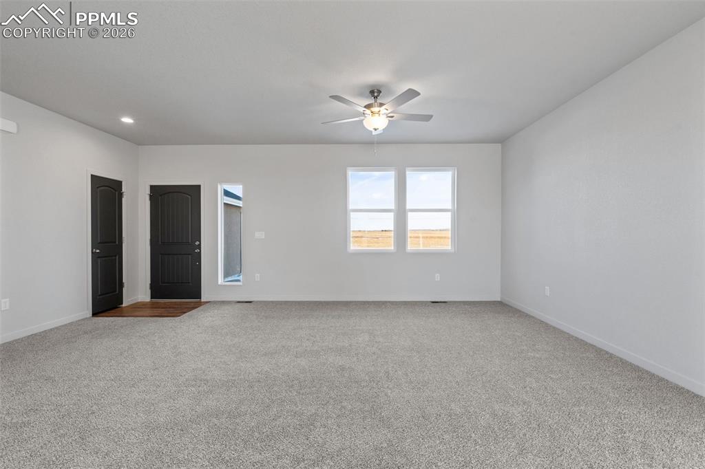 24615 Big Springs Road Calhan, CO 80808 - Photo 23 of 40 an empty room with chandelier fan and windows