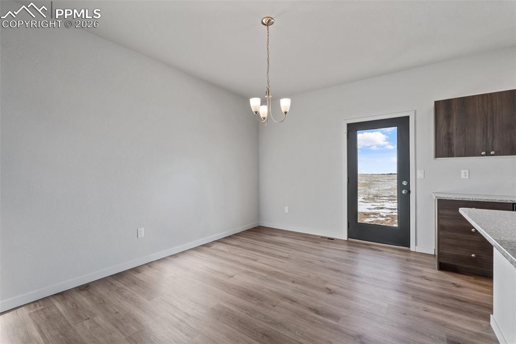 24615 Big Springs Road Calhan, CO 80808 - Photo 26 of 40 an empty room with wooden floor a ceiling fan and windows