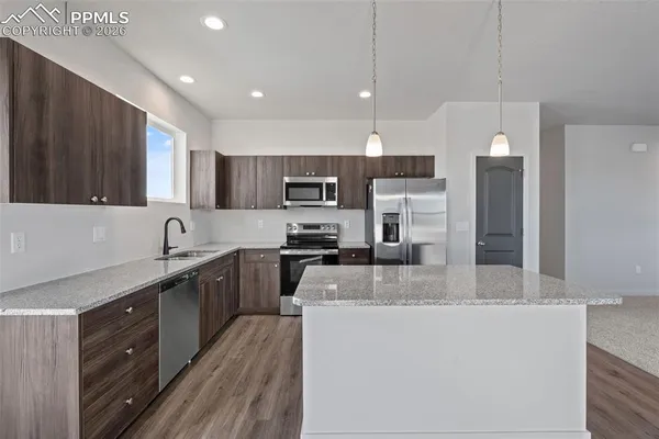 a kitchen with kitchen island a sink stainless steel appliances and cabinets