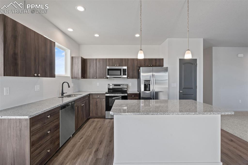 24615 Big Springs Road Calhan, CO 80808 - Photo 6 of 40 a kitchen with kitchen island a sink stainless steel appliances and cabinets