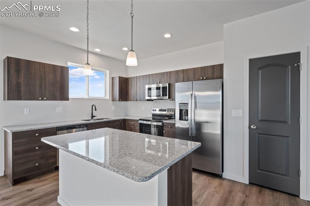 24615 Big Springs Road Calhan, CO 80808 - Photo 7 of 40 a kitchen with stainless steel appliances granite countertop a sink a refrigerator a center island a stove and a center island