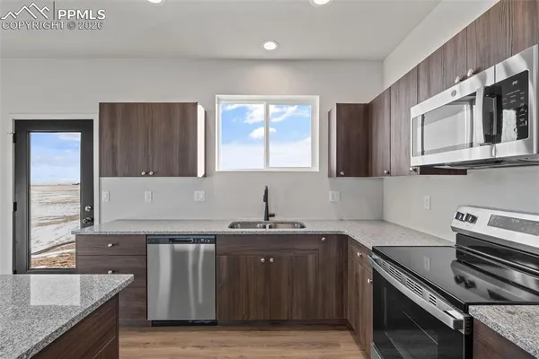 a kitchen with stainless steel appliances granite countertop a sink stove and cabinets
